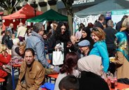 Besucher auf Bänken an den Essenständen