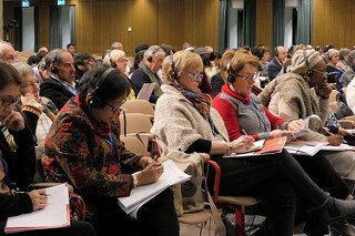 Die Teilnehmer sitzen im Saal, viele schreiben mit