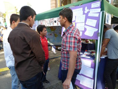 Syrische Jungen gemeinsam mit Mitarbeitern des Zentrum Friedens am Informationsstand
